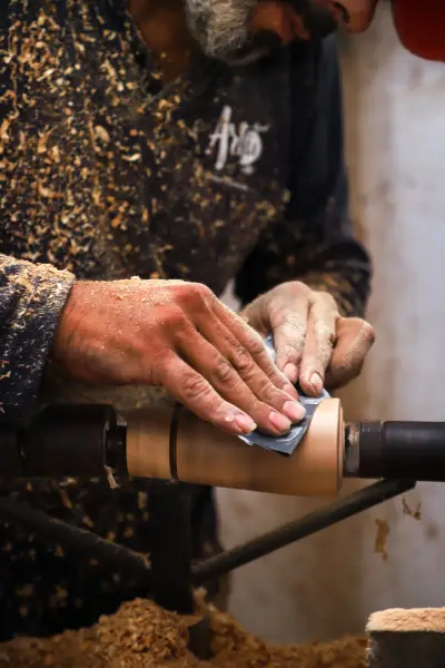 An artisan hand-sanding an olive wood piece
