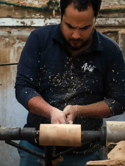 An ArtisRaw artisan shaping an olive wood blank