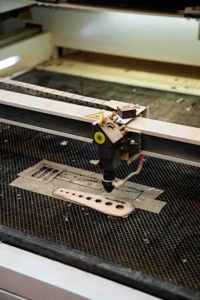 A customer logo being laser-engraved into an olive wood board